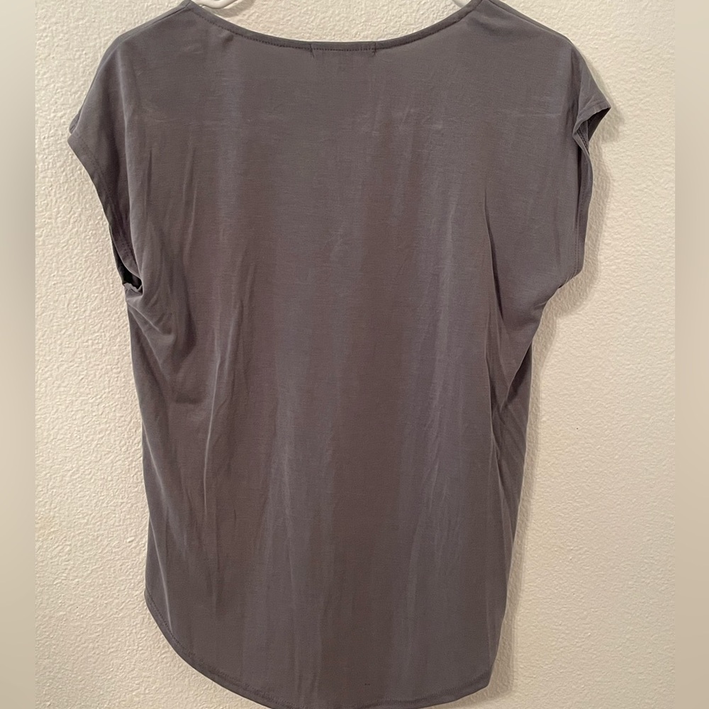 This is a dark gray T-shirt with a part of zipper in the front
